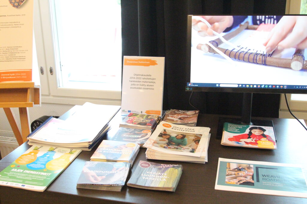 Kuvassa on pöytä, jolla on esillä osaamiseen lisäämistä edistäneissä hankkeissa tuotettuja sisältöjä. 