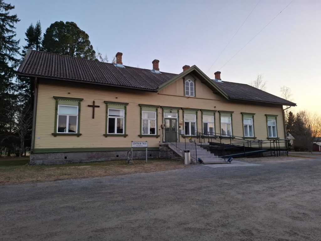 Kuvassa Lohtajan kirkonkylällä sijaitseva keltainen, punatiilikattoinen ja vihreillä koristelaudoilla viimeistelty Lohtaja-talo, joka on valmistunut vuonna 1896.
