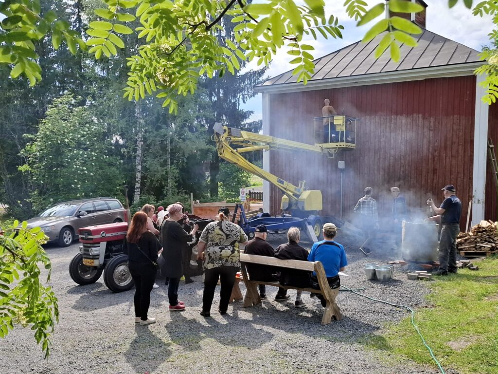 Kuvassa talkooväkeä ja punamultamaalin keiton seuraajia Kaustisen kotiseutumuseon pihalla.